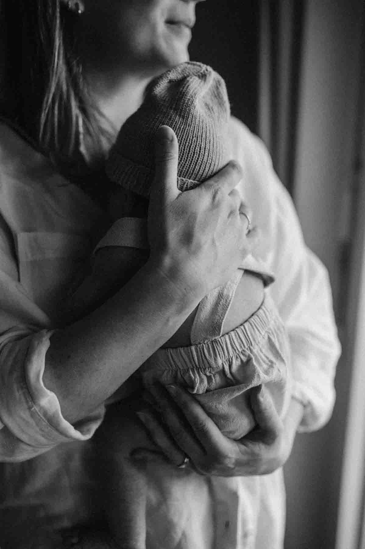 new born baby shooting indoors mama holding baby close